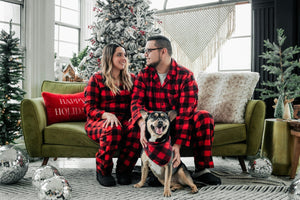 Dog with owners during holidays in front of a Christmas Tree
